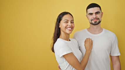 Wall Mural - Confident, beautiful couple enjoying a fun, lovely hug, smiling brightly together against an isolated yellow background. two people, standing casual, expressing pure joy and positive lifestyle