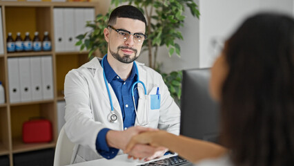 Poster - Confident doctor and cheerful patient joyously shaking hands during their meeting in the clinic's consultation room