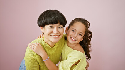 Poster - Confident mother and daughter sharing a lovely, happy hug while smiling and standing together over an isolated pink background, expressing a casual lifestyle full of fun, joy and positive vibes.