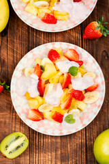 Canvas Print - Fruit salad with yogurt on wooden table.