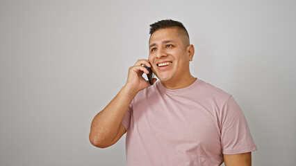 Poster - Cool, confident latin young man engaged in a fun phone talk, smiling happily while holding his smartphone, isolated on a white background