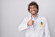 © Krakenimages.com - Hispanic young man wearing doctor uniform doing happy thumbs up gesture with hand. approving expression looking at the camera showing success.
