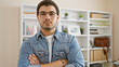 © Krakenimages.com - Casual young man with glasses and beard standing arms crossed in a modern office setting.