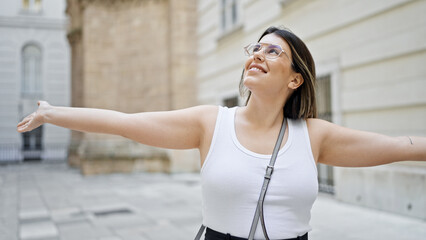 Wall Mural - Young beautiful hispanic woman with open arms in the streets of Vienna