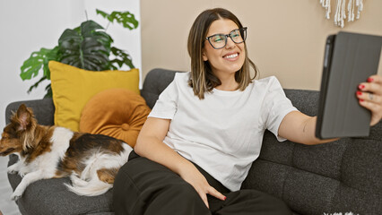 Canvas Print - A young woman takes a selfie with her dog on the couch in a cozy living room setting.