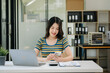 © laddawan - Asian business woman typing laptop and tablet Placed at the table at the office.