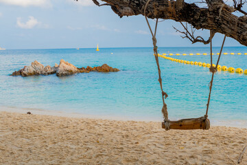 View of the beach, sea, beautiful rocks during the day and swings at the beach.