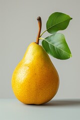 Aufkleber - a ripe yellow pear with a green leaf positioned on top of it.