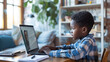 African american boy typing message on laptop during video call while learning in online class. Cute little african american boy studying with laptop with headphones remotely at home enjoying distance