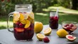 A glass jar of lemonade with sliced lemons and strawberries