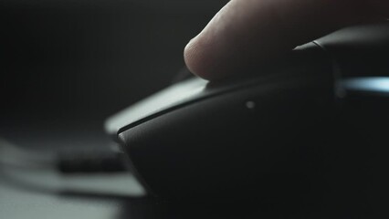 Clicking black computer mouse on a work desk. Close up. 
