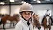Cheerful young horseback rider in helmet at equitation lesson, smiling at camera