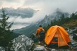 Amidst the foggy mountain landscape, a lone hiker rests beside their trusty tent, surrounded by the rugged beauty of nature and their essential hiking equipment