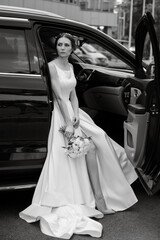 bride with a black car near a glass skyscraper