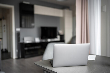  Workplace with laptop in living room of real apartment, home office concept