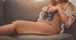 © sornthanashatr - mother, family, maternity, pregnant, woman, pregnancy, baby, motherhood, love, happiness. pregnancy, motherhood, close up of happy pregnant woman and holding small baby shoes sit on sofa and smiling.