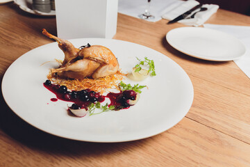 Wall Mural - Roasted Quail with rosemary and spices on the wood background.