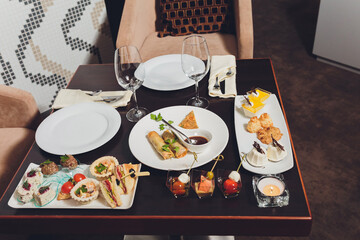 Wall Mural - Different canapes with smoked salmon, cucumber cherry tomatoes and mozzarella served on a table.