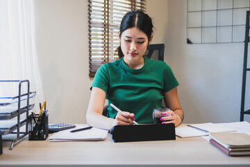 Wall Mural - Businesswoman working at desk using tablet.