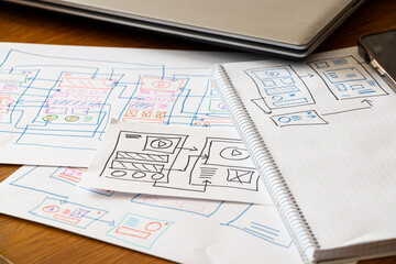 Development and sketches on paper of a custom mobile application on the desktop, graphic design