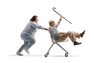 Poster - Woman pushing an elderly gentleman inside a shopping cart