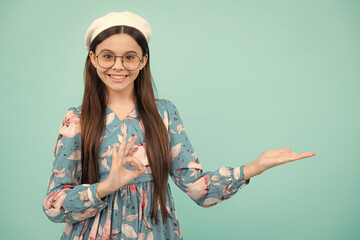 Sticker - Happy teenager, positive and smiling emotions. Close up portrait of teenager child girl showing at copy space, pointing to ads advertising, isolated over white background.