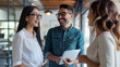 © MP Studio - Two professionals holding tablets are engaged in a cheerful conversation with a smiling colleague in a modern office environment.