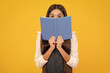 Schoolgirl with copy book posing on isolated background. Literature lesson, grammar school. Intellectual child reader.
