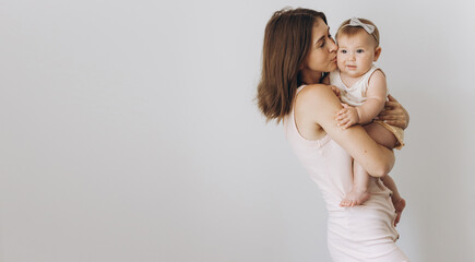 Happy young mother with her adorable baby girl on white background