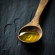 Olive oil in a wooden spoon on a black texture background. Food photography for your creativity.