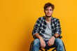 Disabled young man in wheelchair on yellow background
