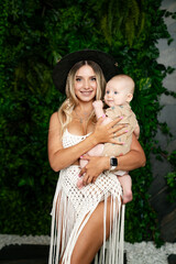 Wall Mural - Young mother and her baby in white dress and in black hat