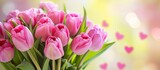 Fototapeta Tulipany - A beautiful arrangement of pink tulips in a vase, set against a backdrop of heart designs. The vibrant magenta petals stand out against the green grass, creating a lovely natural landscape.