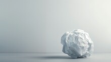 Crumpled white paper ball on grey background