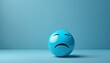 Blue Monday concept with sad emoji face on a light blue background