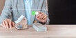 © yuwadee - house and pile of money ,insurance concept,coverage ,Investing, real estate, and home mortgages, savings, for financial freedom, immersive touch screen, copy space.