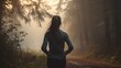 young sporty woman preparing to run in early foggy morning in the beautiful nature forest, wellness concept