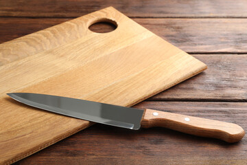 Sticker - One sharp knife and board on wooden table, closeup