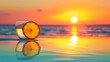 A glass with a slice of orange on the rim, against a sunset over the ocean