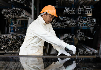 Male glass technician works on installing glass using installation tools and checking the condition of the work piece.