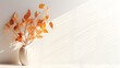 Home interior decor elements. Dry autumn leaves in vase near white wall with sunlight shadows. Empty space for product, artwork