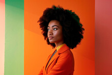 Young businesswoman with afro, and office attire against  backdrop of warm orange and cool green