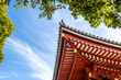 Details of corner of Japanese traditional temple roof with blue sky and tree, copy space