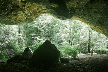 Wall Mural - A wild cave or grotto. Mountainous terrain. Summer time of the year.