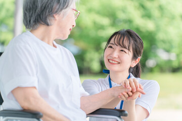 Poster - 病院・介護施設で散歩しながら話す車椅子に乗った高齢者と介護士（ヘルパー・理学療法士）
