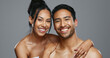 © Felix/peopleimages.com - Couple, smile and care for skincare, happy and portrait for wellness in studio by gray background. Happy people, dermatology and hug for cosmetics, hydration and glow or love for skin treatment