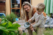© Halfpoint - Mother and son taking care of plants in the garden, replanting, watering flowers. Mom and boy spending quality time together, bonding.
