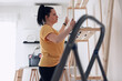 © astrosystem - Woman assembling new wooden shelf and furniture in the apartment.