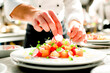 © NORN - Chef Garnishing Plates with Precision in Kitchen.