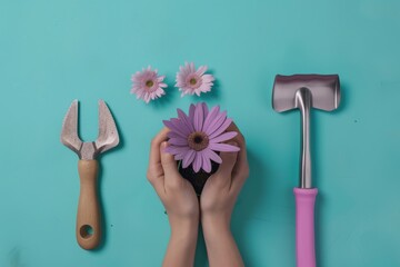 Top view of hands holding flower to plant with gardening tools